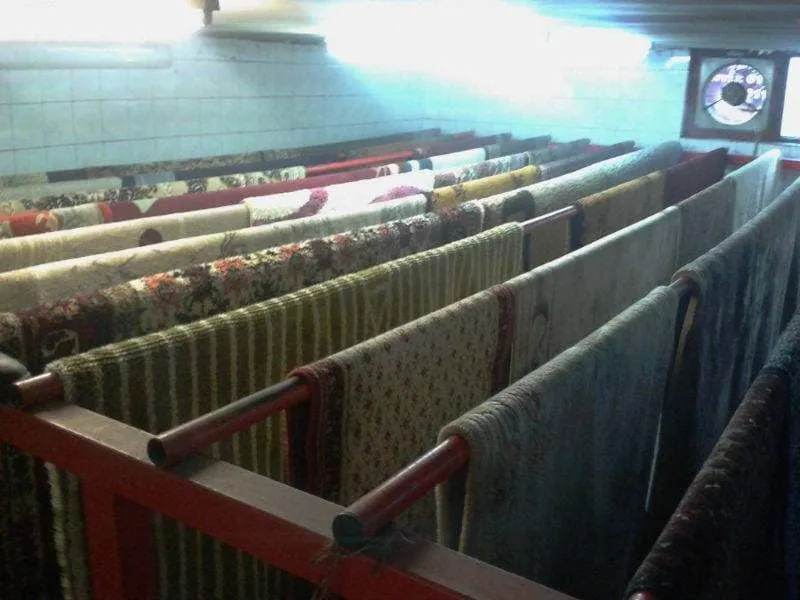 Oprani tepisi okačeni na sušenje u komori servisa