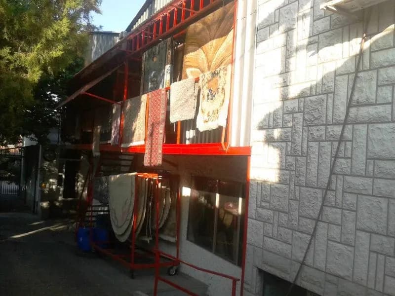 Tepisi okačeni na sušenje uz fasadu objekta servisa